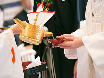 花束や升酒で飾られた会場内に立つ、和傘をさした和装の花嫁